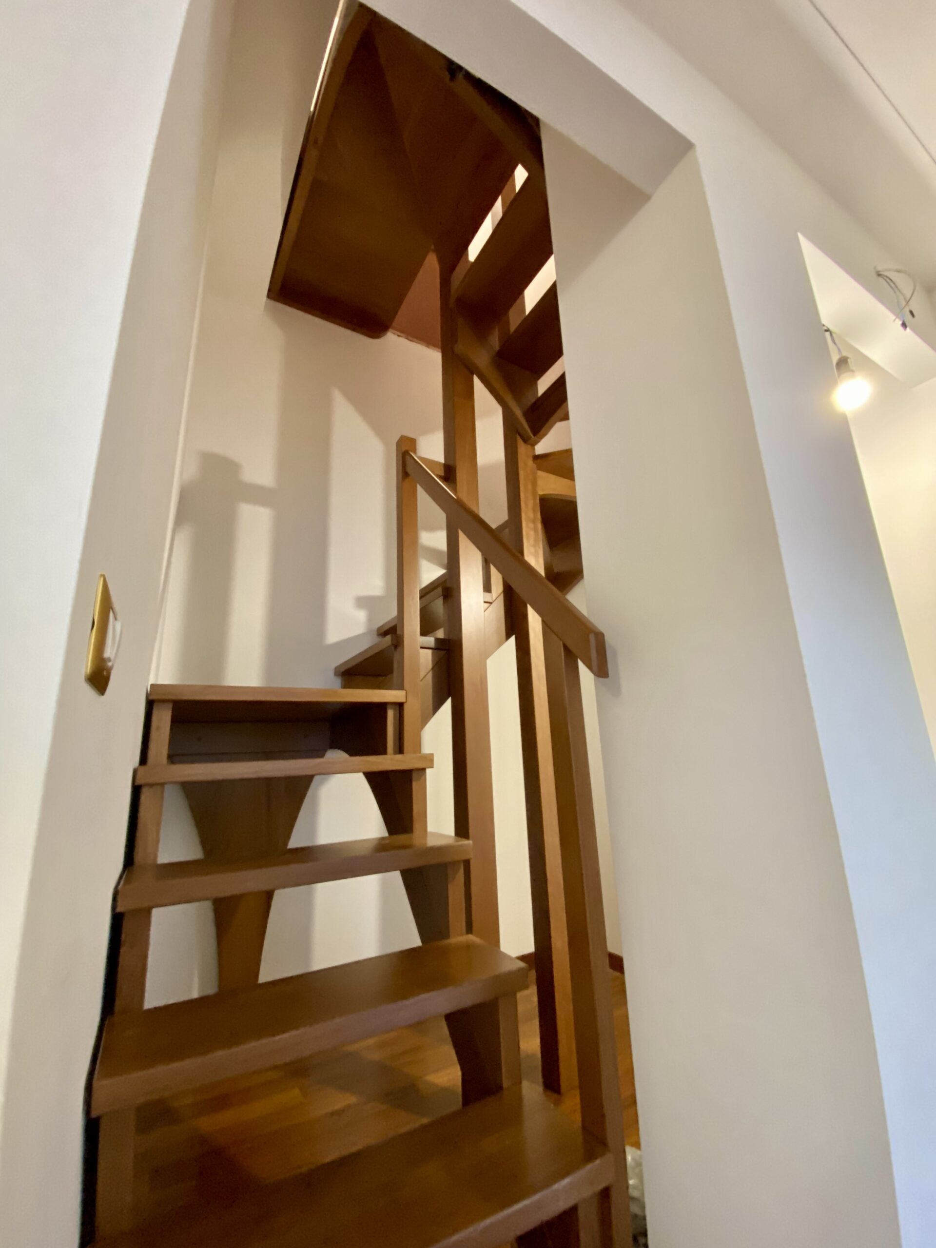 Scala su misura in legno vista dal basso realizzata a Roma per collegamento a mansarda in spazio ridotto