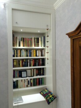 Libreria su misura bianca inserita in una nicchia con illuminazione
